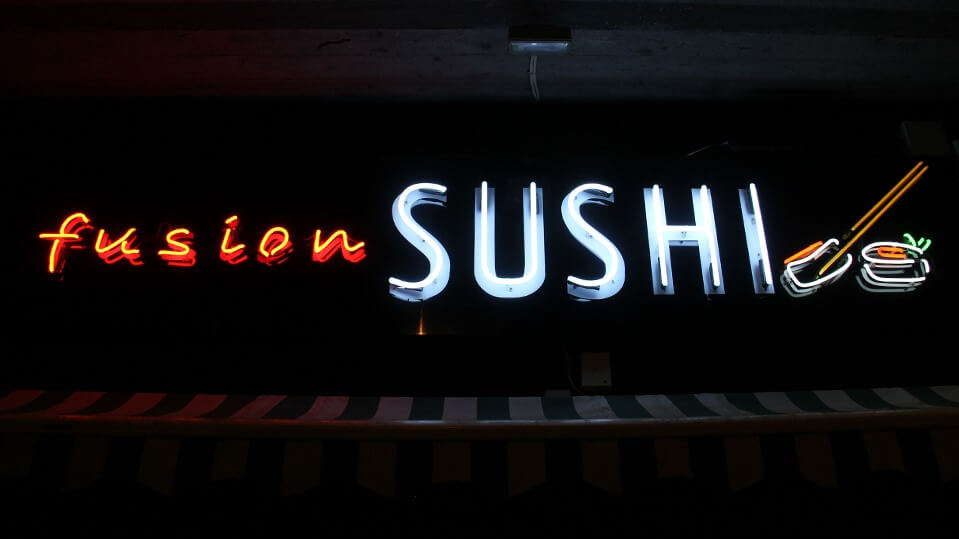 Fusion Sushi advertising neon sign, located above the entrance to the building