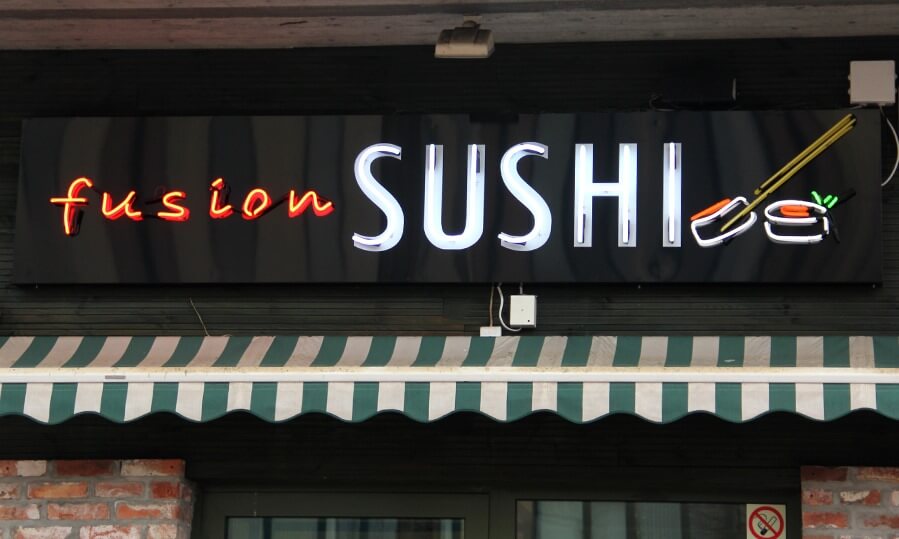 Fusion Sushi advertising neon sign, located above the entrance to the building