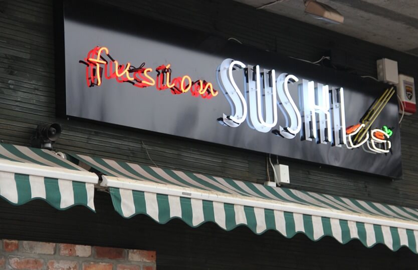 Fusion Sushi advertising neon sign, located above the entrance to the building