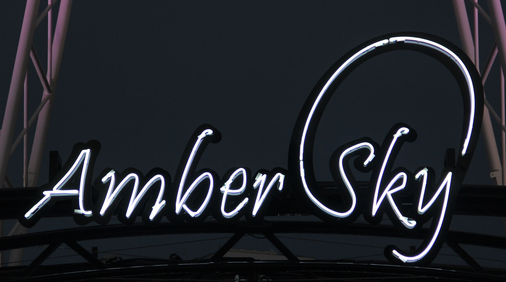 Cielo ámbar - Amber Sky - cartel de neón blanco con el nombre de la empresa colocado en el estante