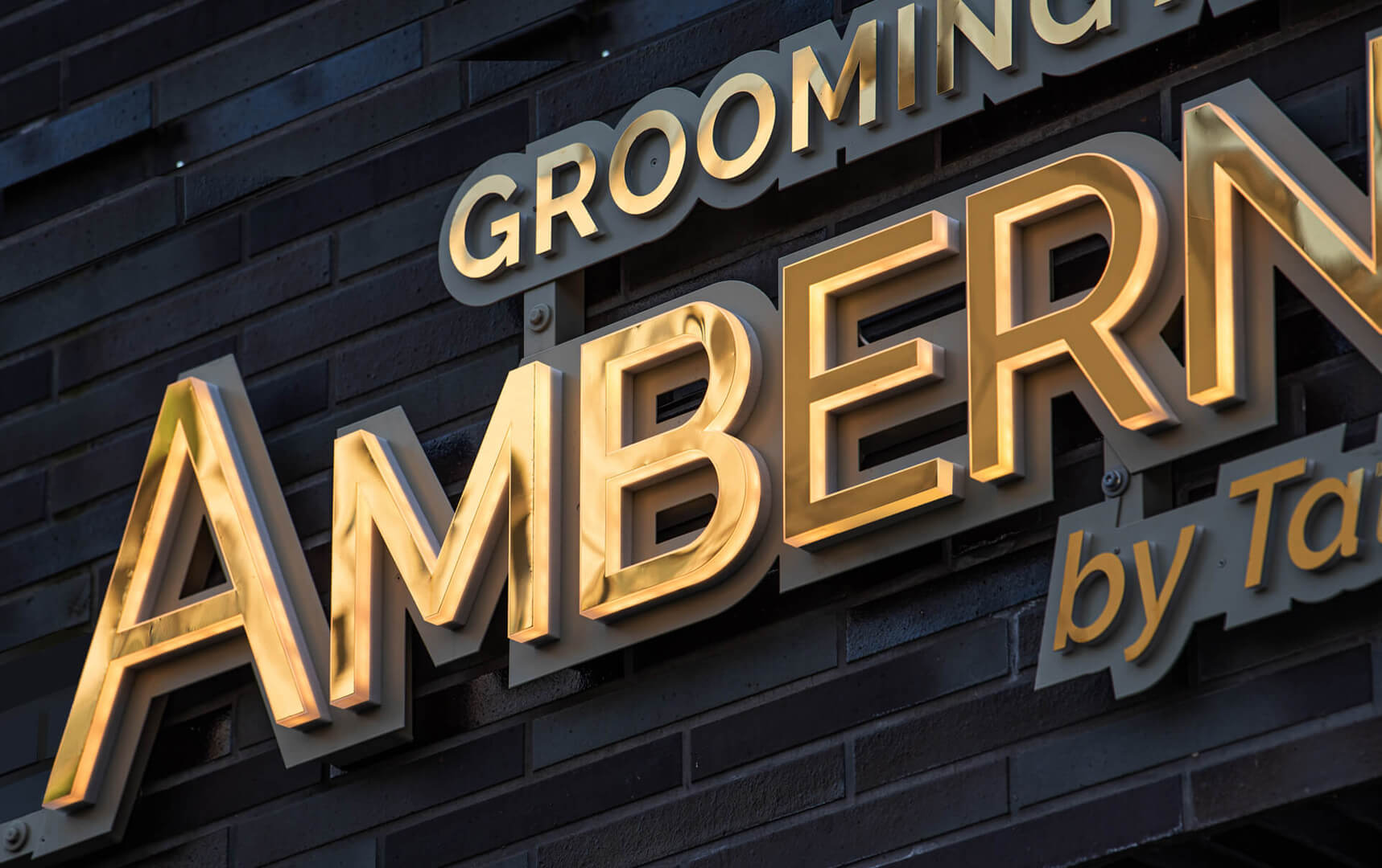 Ambernova - Seitlich beleuchtete LED-Buchstaben Ambernova aus goldfarbenem Edelstahl.