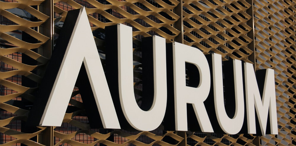 Aurum - Aurum - Lettere di luce spaziale a LED poste sopra l'ingresso su una cornice