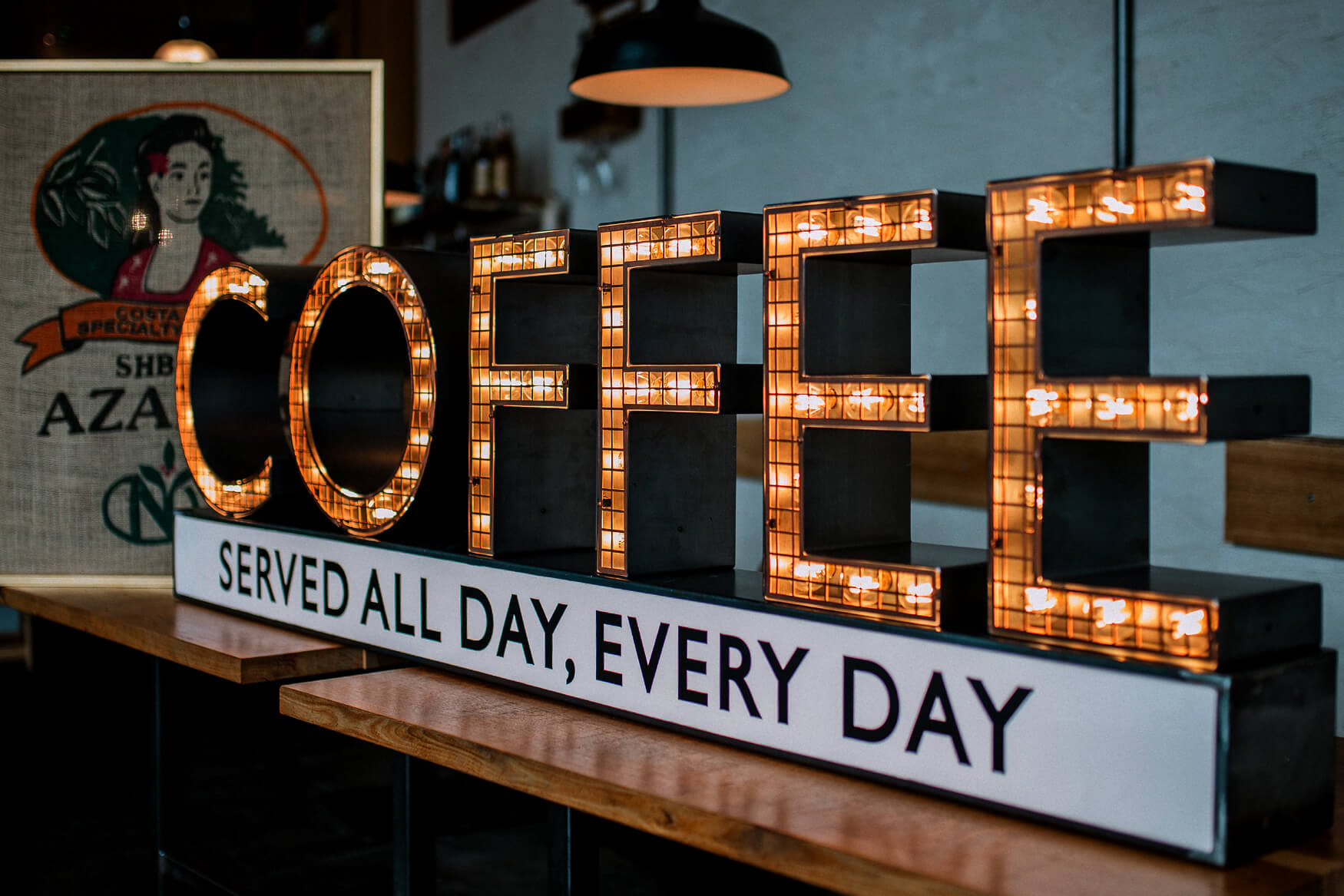 Kaffee - Kaffee - Briefe mit Glühbirnen auf einem Rahmen