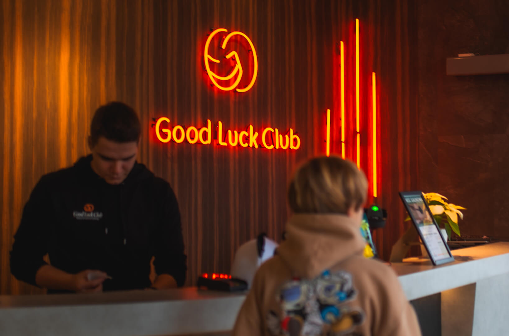 Good Luck Club - Rood neonbord in de receptie met het bedrijfslogo.