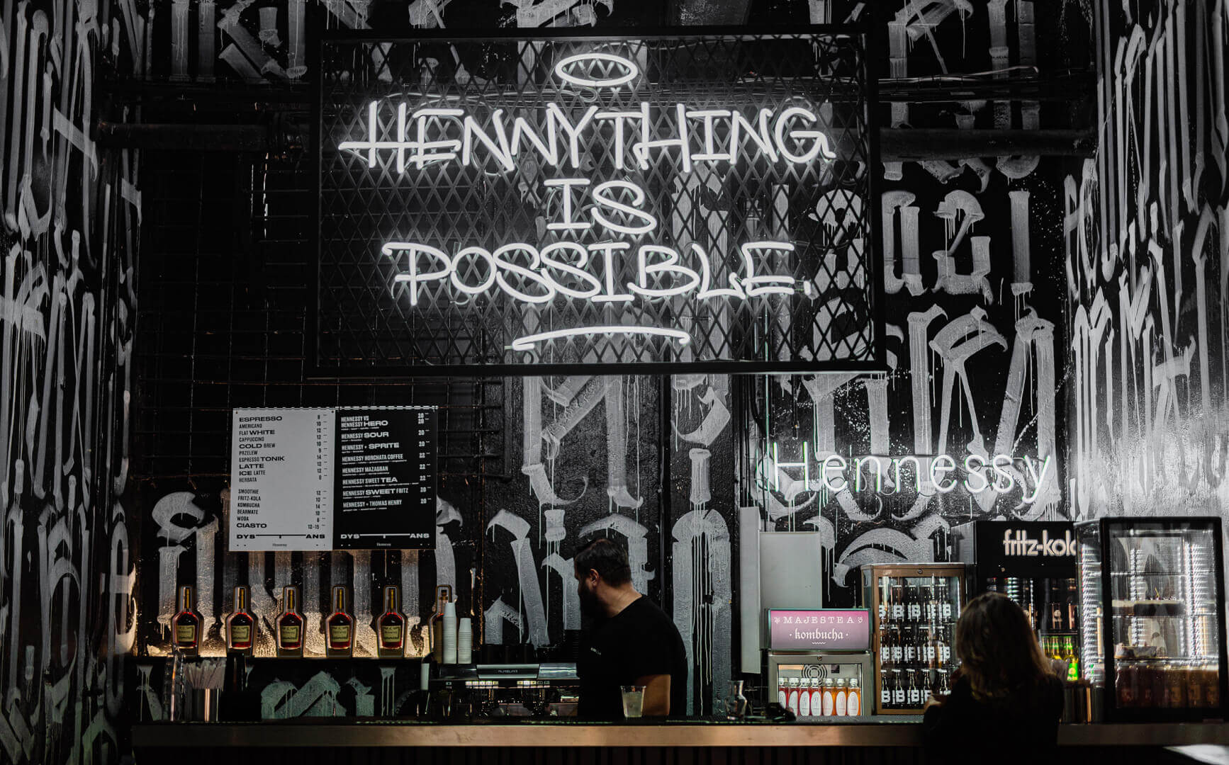 Bei Henny ist alles möglich - Neonschild auf einem Gitter über einer Bar in Gdańsk.