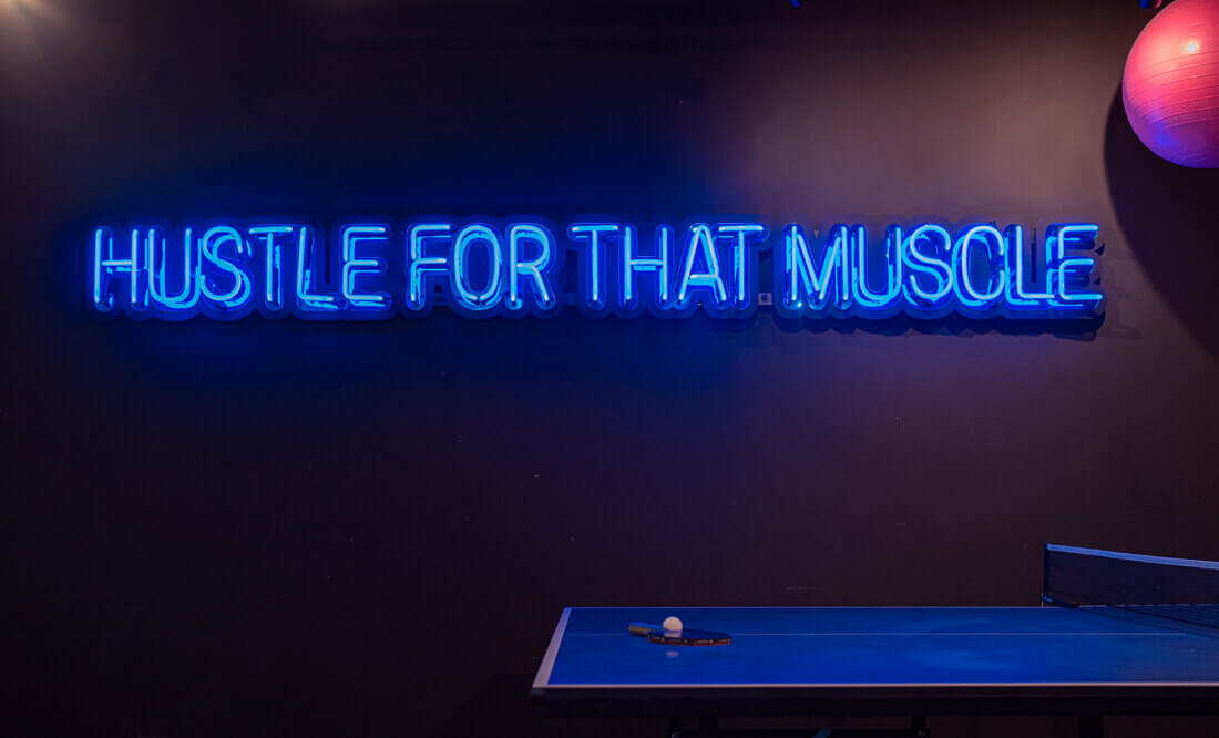Hustle for that muscle - blue neon on wall