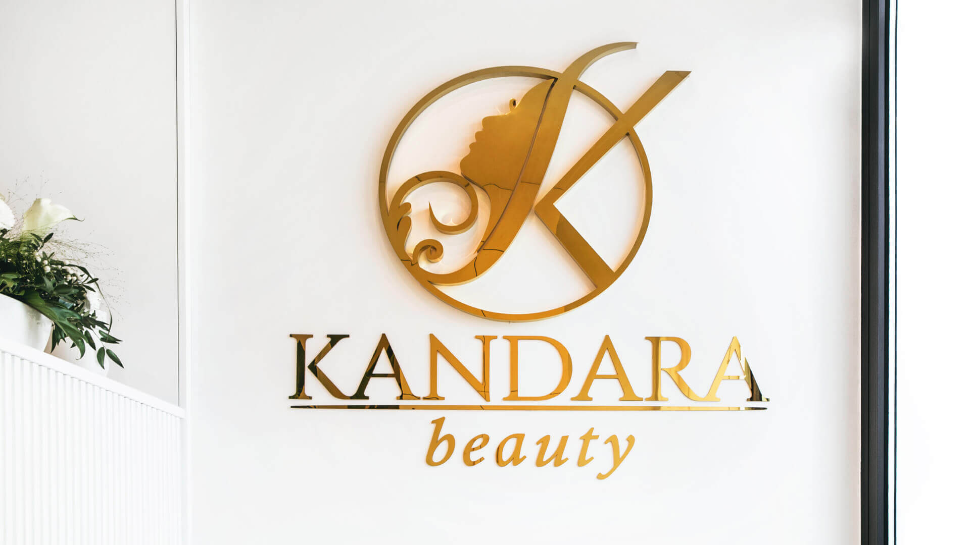 Kandara Schönheit - Logo mit Namen aus goldfarbenem Edelstahl.