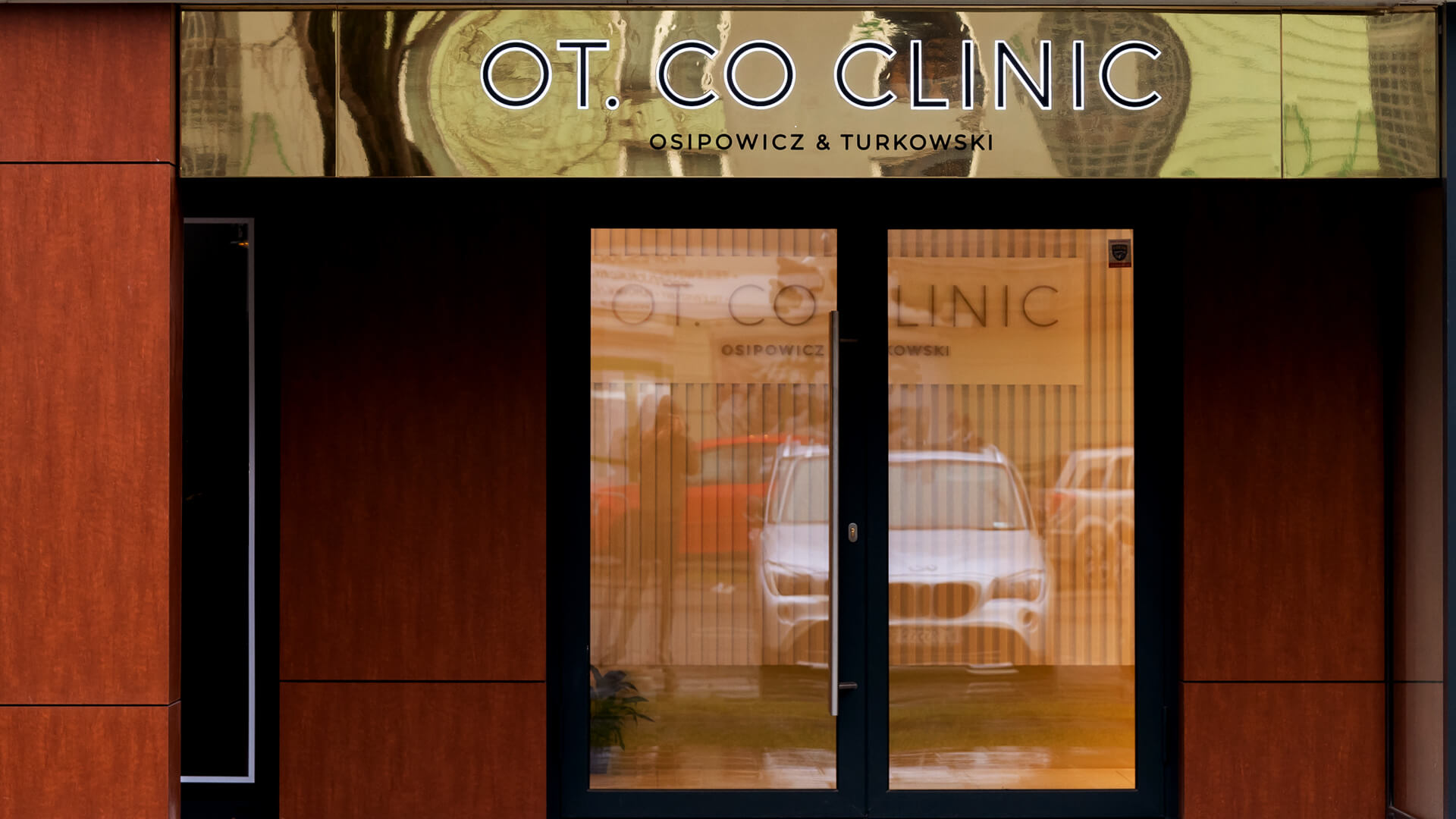 Clínica OT.CO - Arca publicitaria dorada sobre la entrada de la clínica OT.CO