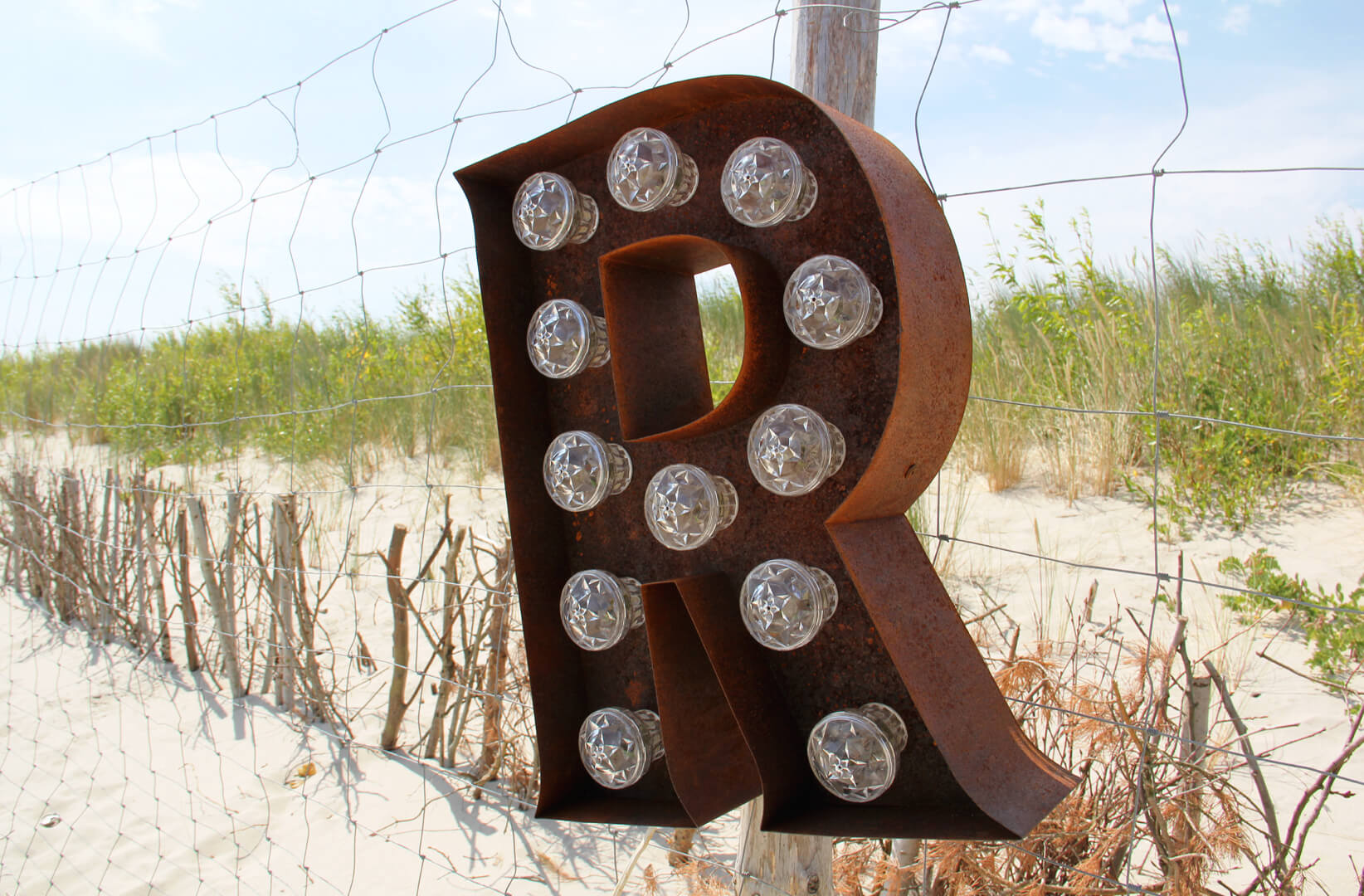 Rusty letters with light bulbs - letters-light-rusty-industrial-metal-letters-illuminated-letters-spatial-letters-metal-glowing-retro-letters-on-the-beach