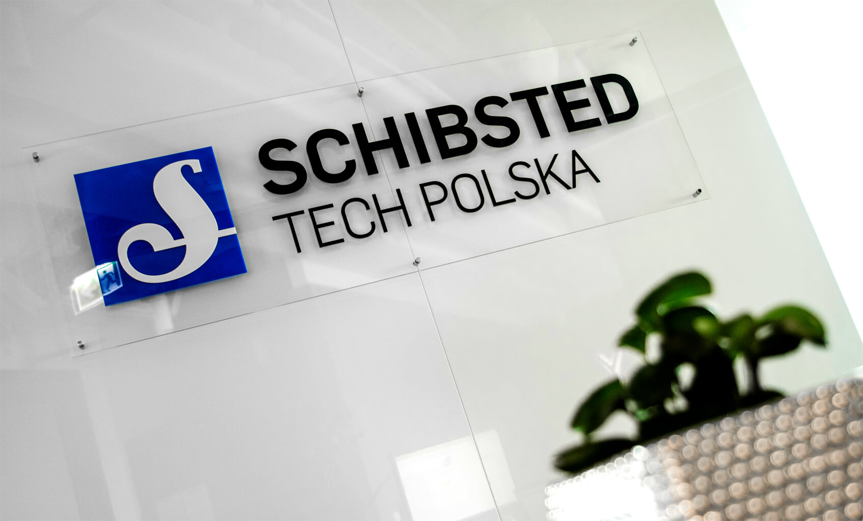 Schibsted Tech Polska - Schibsted Tech Polska - logo i litery przestrzenne 3D na podstawie plexi na dystansach w recepcji