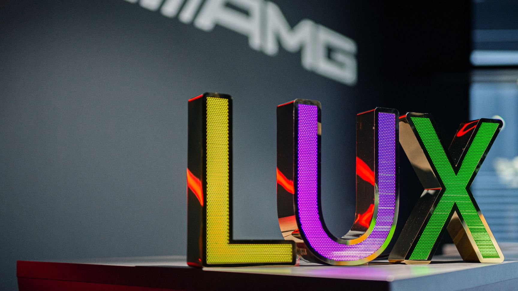 LUX-Buchstaben aus perforiertem Edelstahl - LUX-Schriftzug aus perforiertem Edelstahl, dreifarbig LED-hinterleuchtet im Mercedes-Showroom