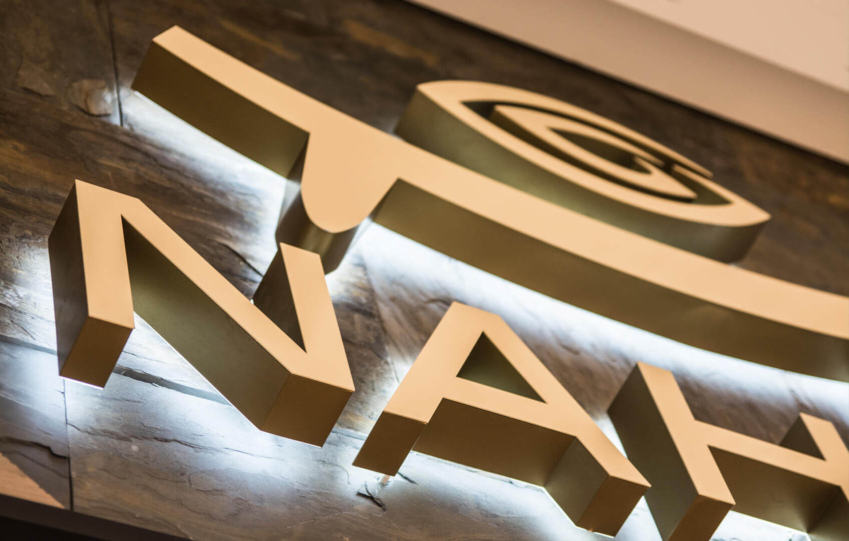 NAHUA - Nahua - litery świetlne LED umieszczone na ścianie, widoczny efekt halo