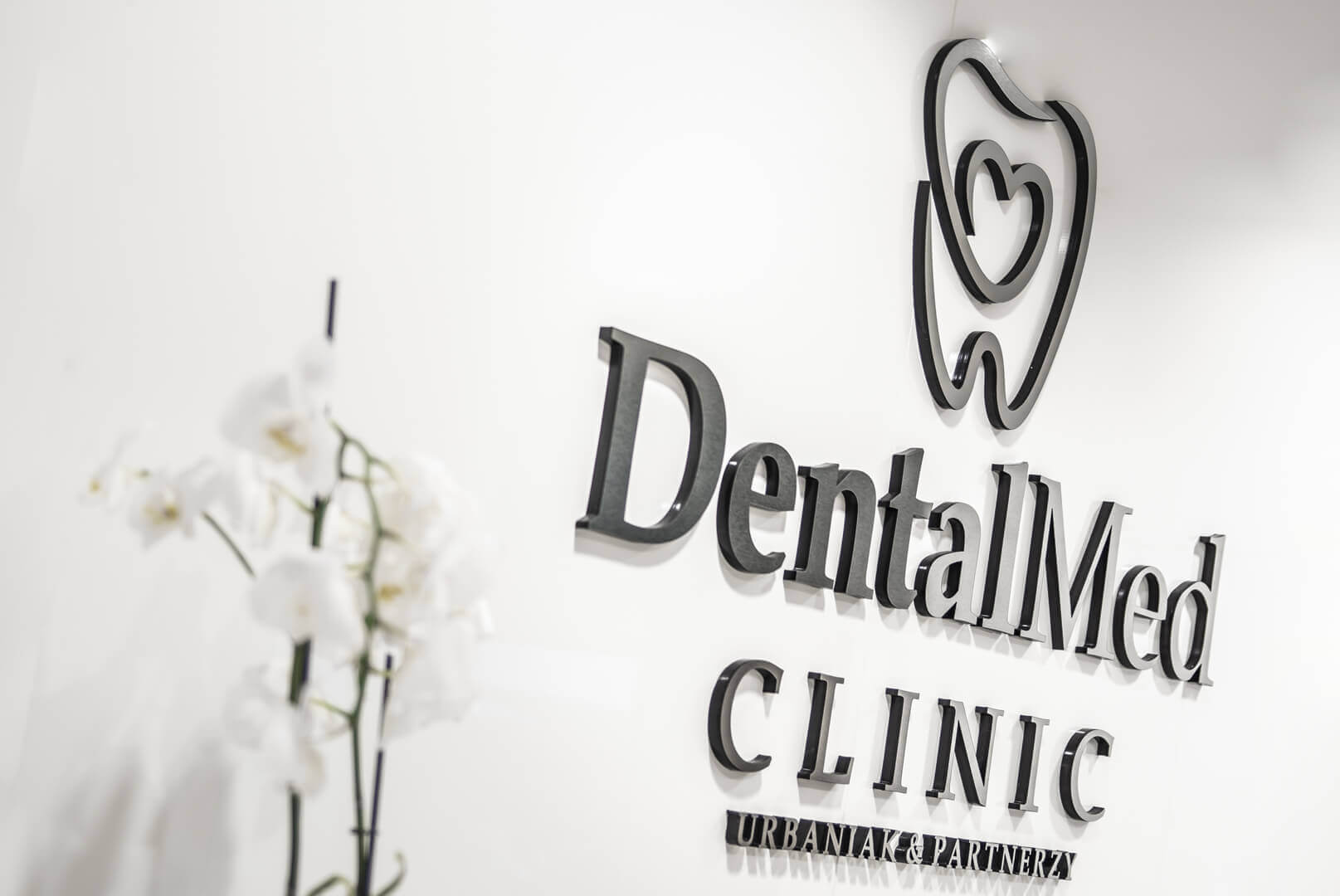 DentalMed - DentalMed - Logo und 3D-Buchstaben aus Plexiglas neben dem Empfangstresen