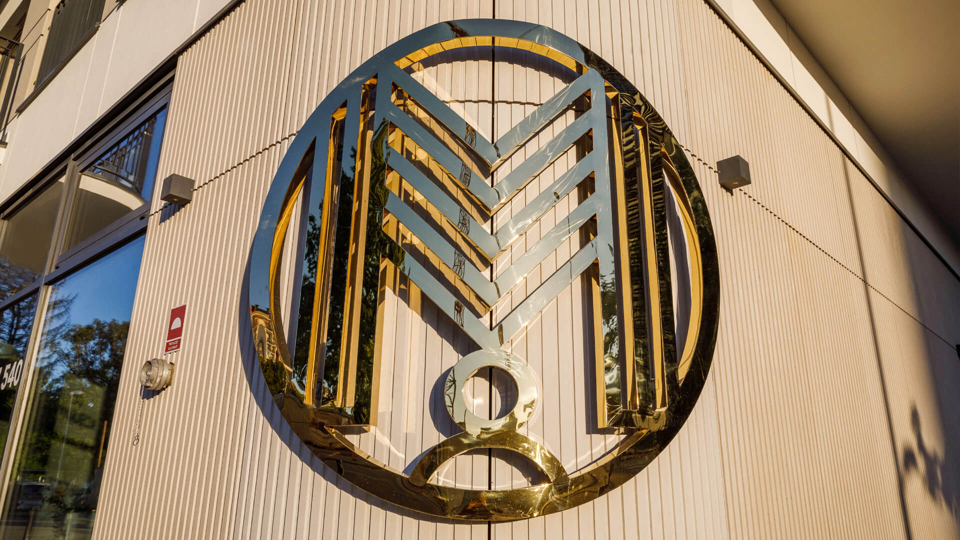 Gewölbtes Logo - Abgerundetes Edelstahllogo in Gold.