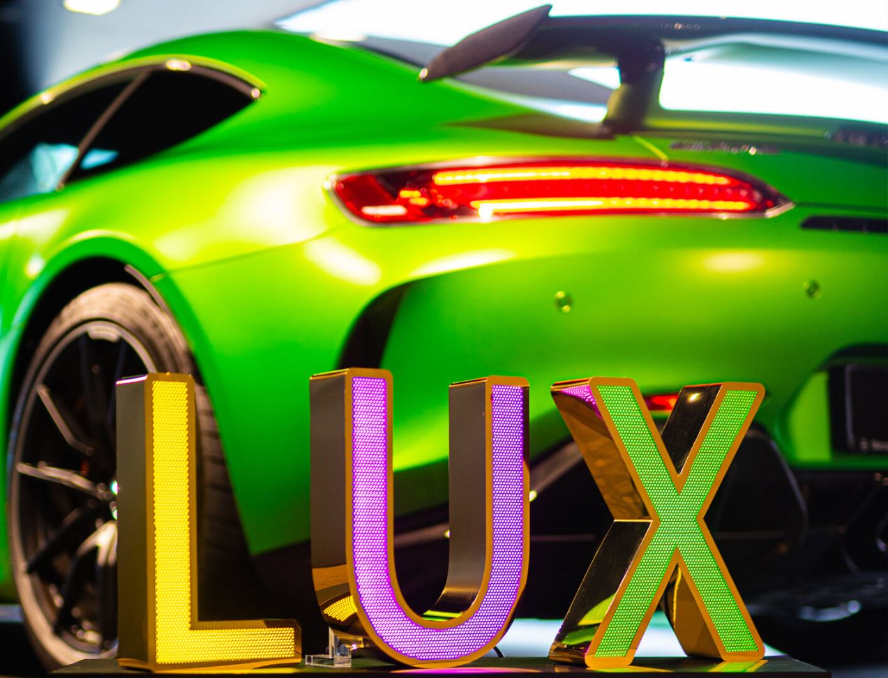 LUX litery z blachy nierdzewnej perforowanej - Litery LUX ze złotej połyskującej blachy nierdzewnej perforowanej, podświetlanej LED, w salonie Mercedesa
