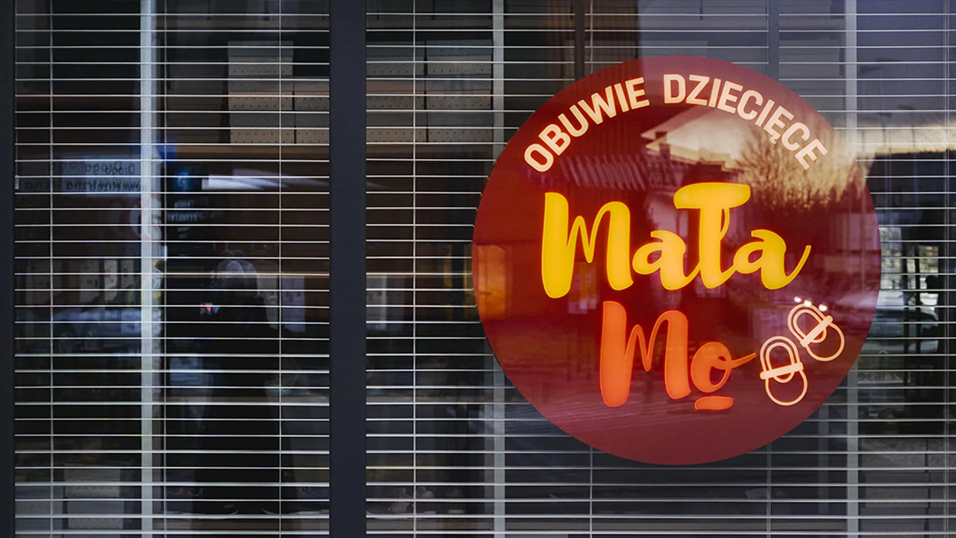 Piccolo Mo - negozio illuminato, dietro un vetro giallo e rosso.