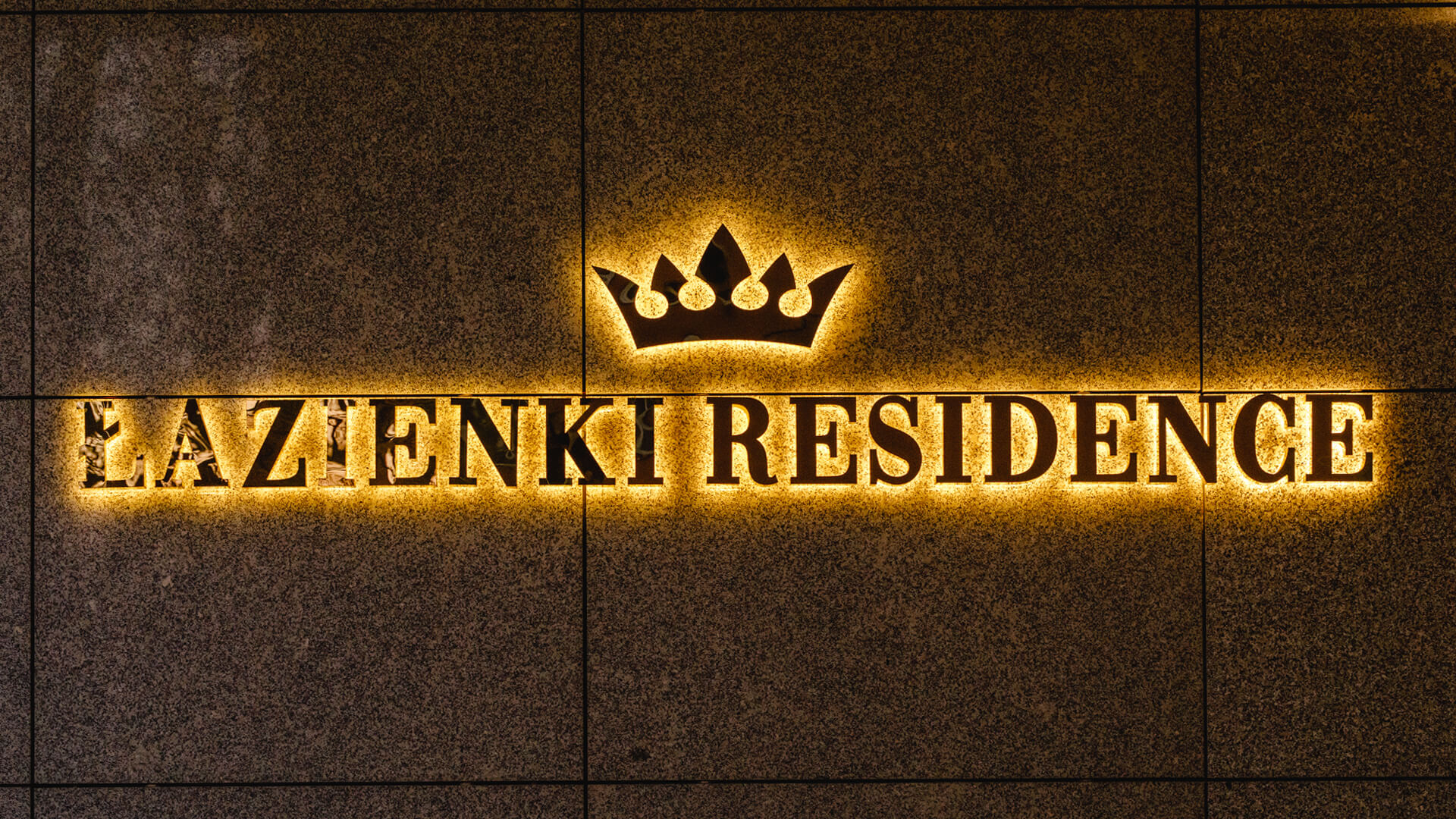 Baths Residence - Bathroom Residence lettering made of stainless steel in gold, back-lit LED on the wall, with a crown in the logo.