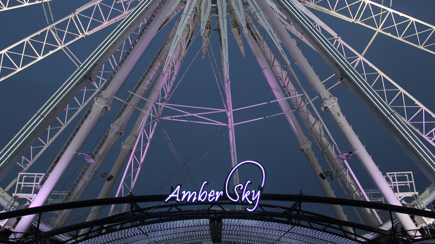 Bernsteinfarbener Himmel - Amber Sky - weißes Neonschild mit Firmenname auf dem Regal