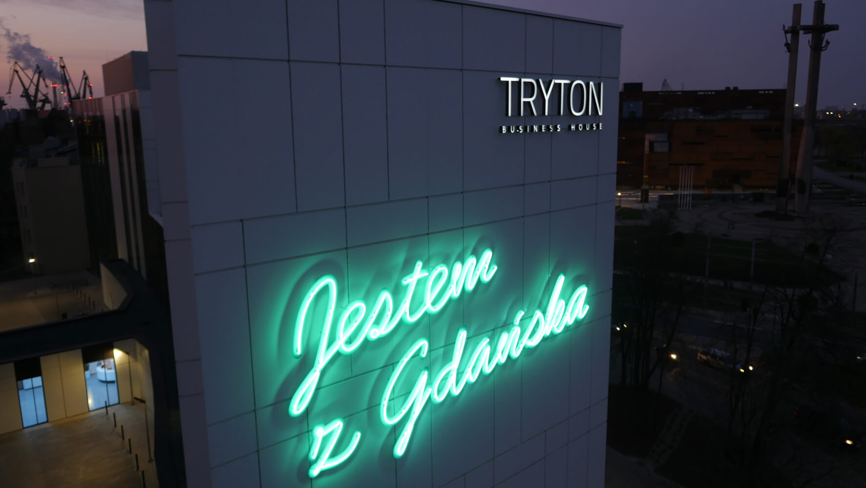 Triton - Tryton - inscription "Je suis de Gdańsk" créée à partir d'enseignes au néon, placée sur la façade.
