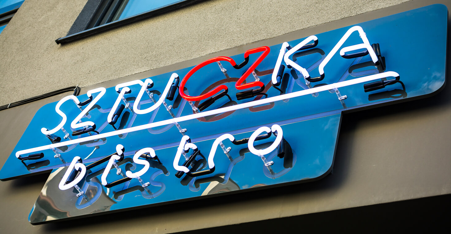 Trick Bistro - Sztuczka Bistro - neon sign for bistro, mounted on plexiglass, placed over the entrance