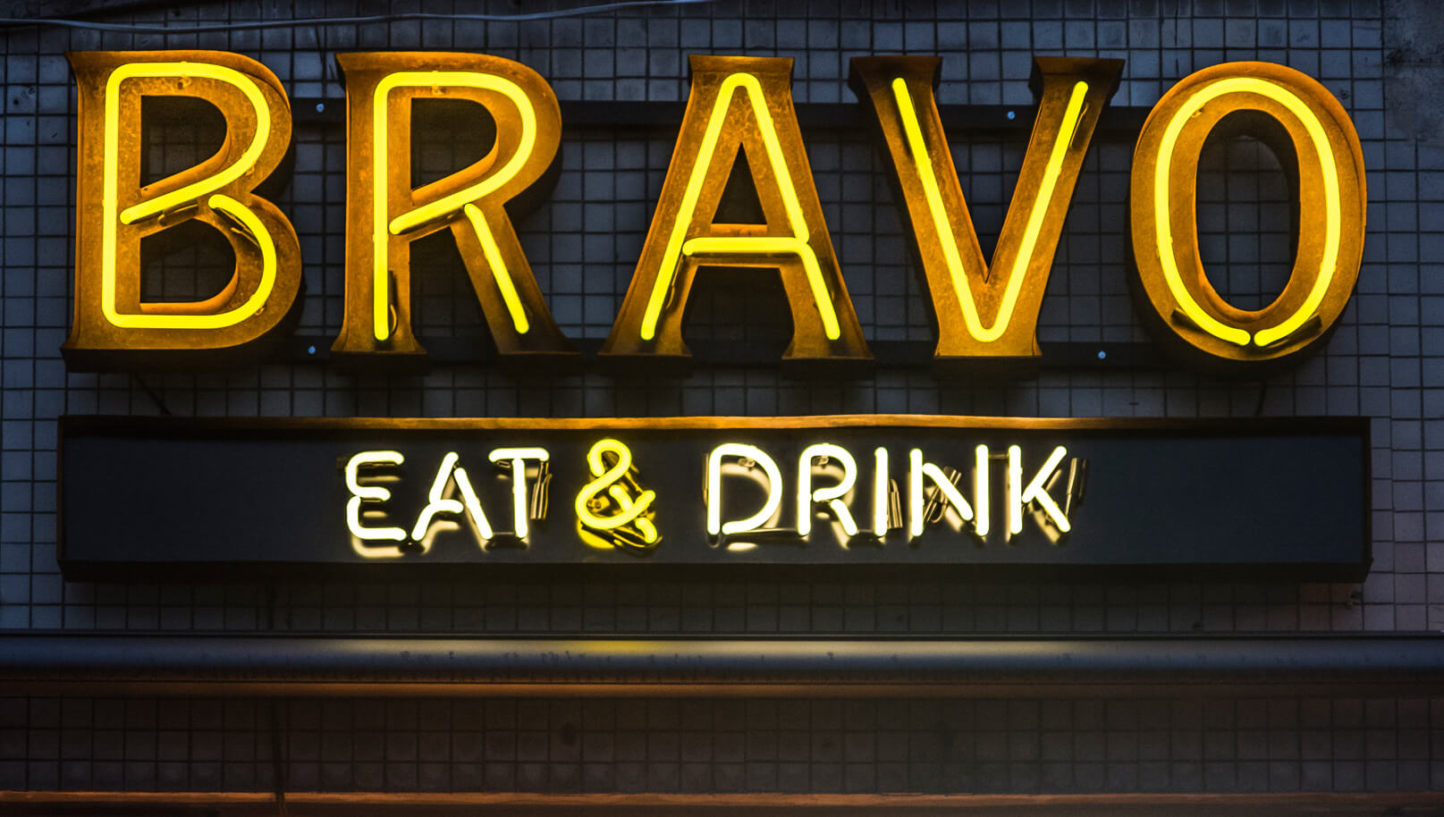 BRAVO - neon-bravo-eat-drink-neon-nad-wejsciem-do-restauracji-neon-na-kaflach-neon-na-scianie-z-kafli-neon-podswietlany-neon-wewnatrz-blachy-nierdzewnej-neon-na-zewnatrz-zolty-neon-warszawa-centralna