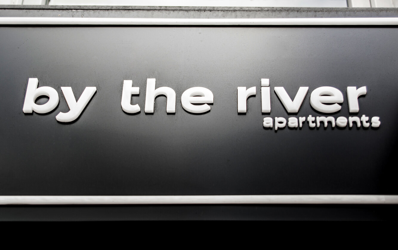 by the river - by the river - a company sign placed on an advertising coffer