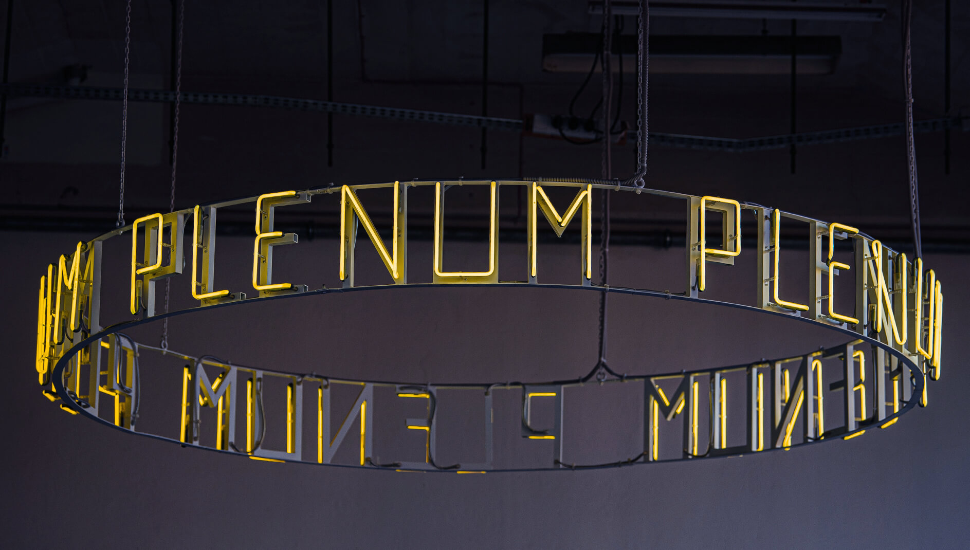 Neon Plenum - Okrągły neon Plenu na suficie, w kolorze żółtym.