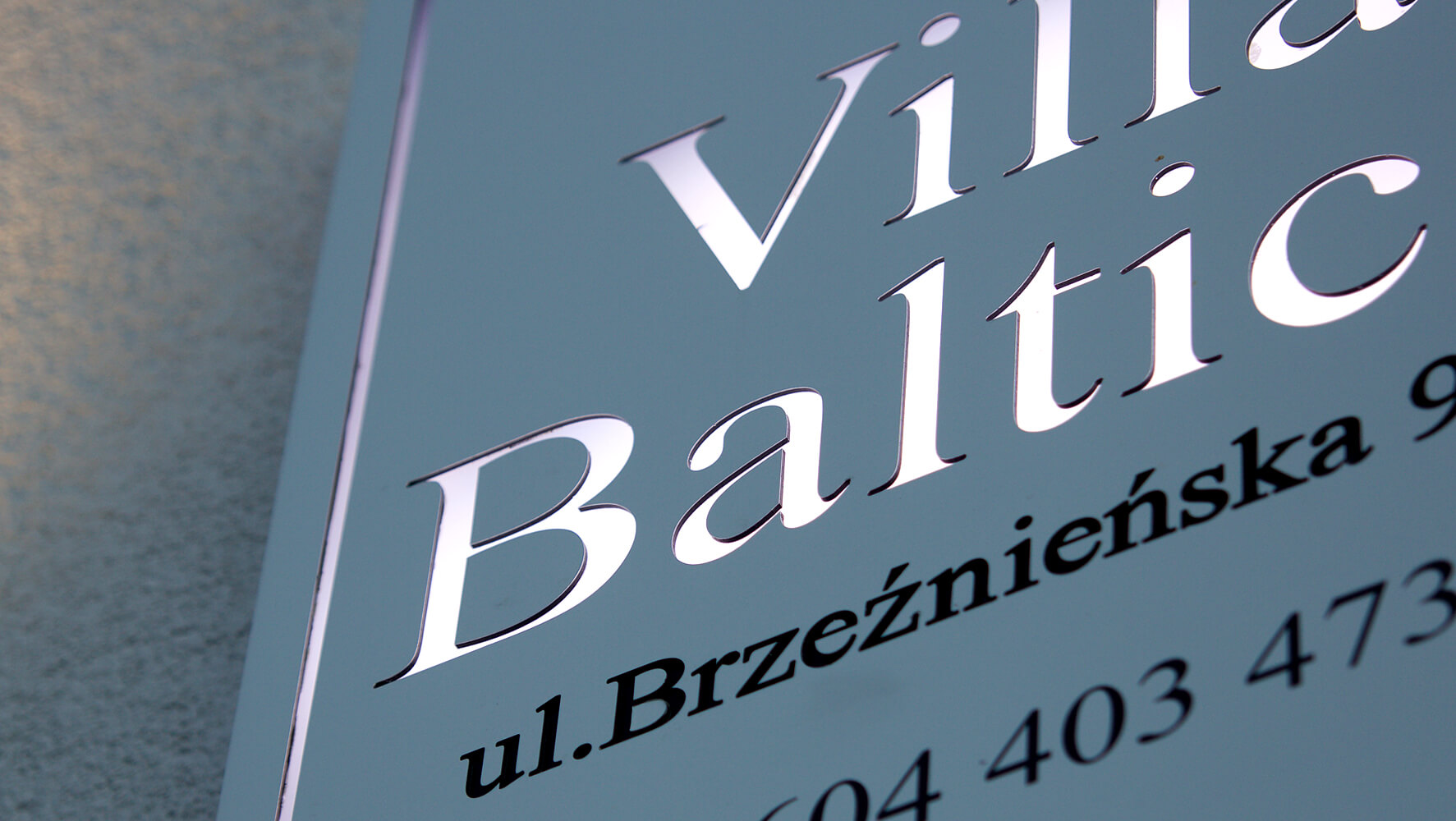 Villa Baltica - Villa Baltica - Firmenschild auf einem Dibondkoffer