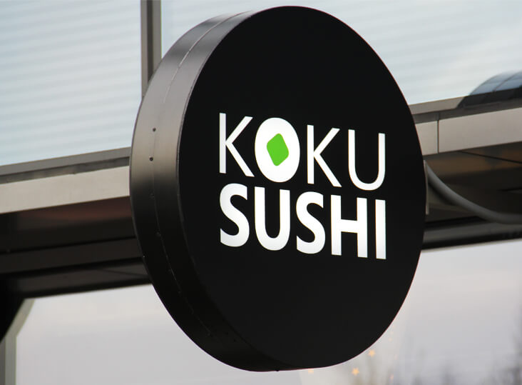 Koku Sushi - Koku Sushi - okrągły świetlny kaseton reklamowy obok wejścia
