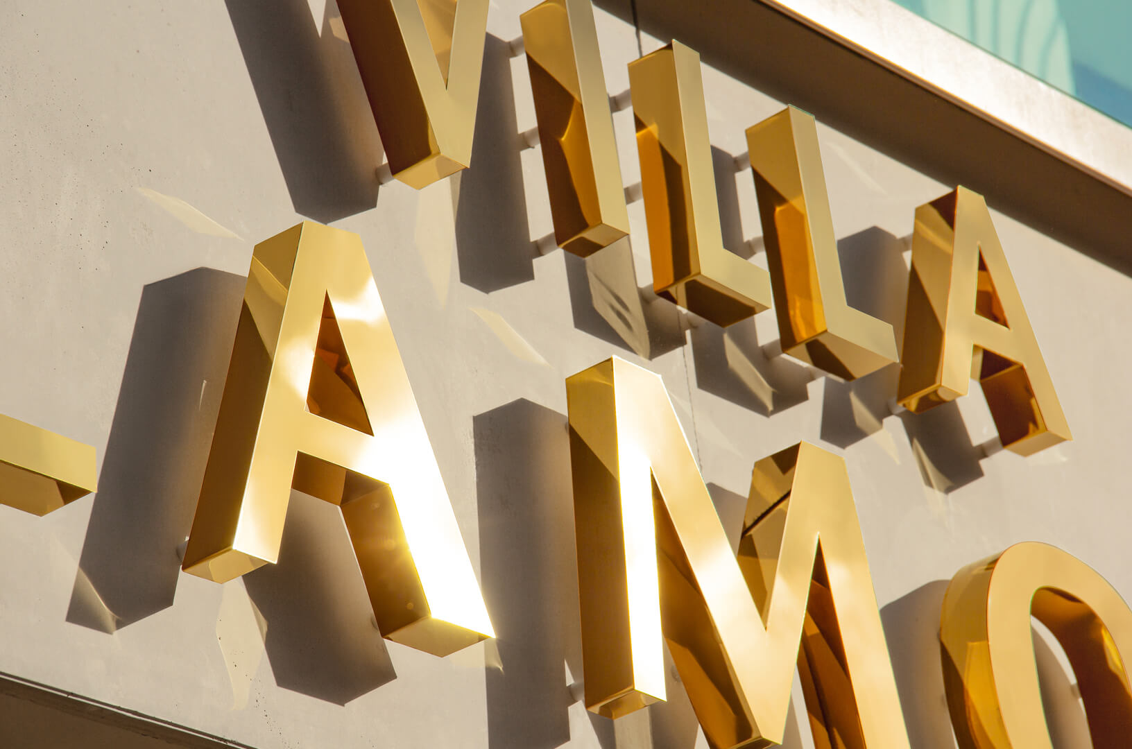 Villa Glamour - letters made of gold polished stainless steel, back-lit on the wall