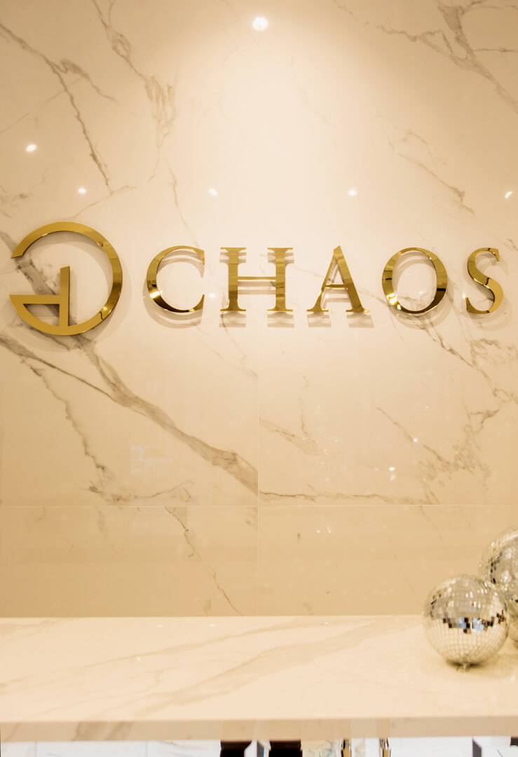 CHAOS - Chaos - złote logo i litery przestrzenne 3D wykonane z plexi umieszczone na ścianie