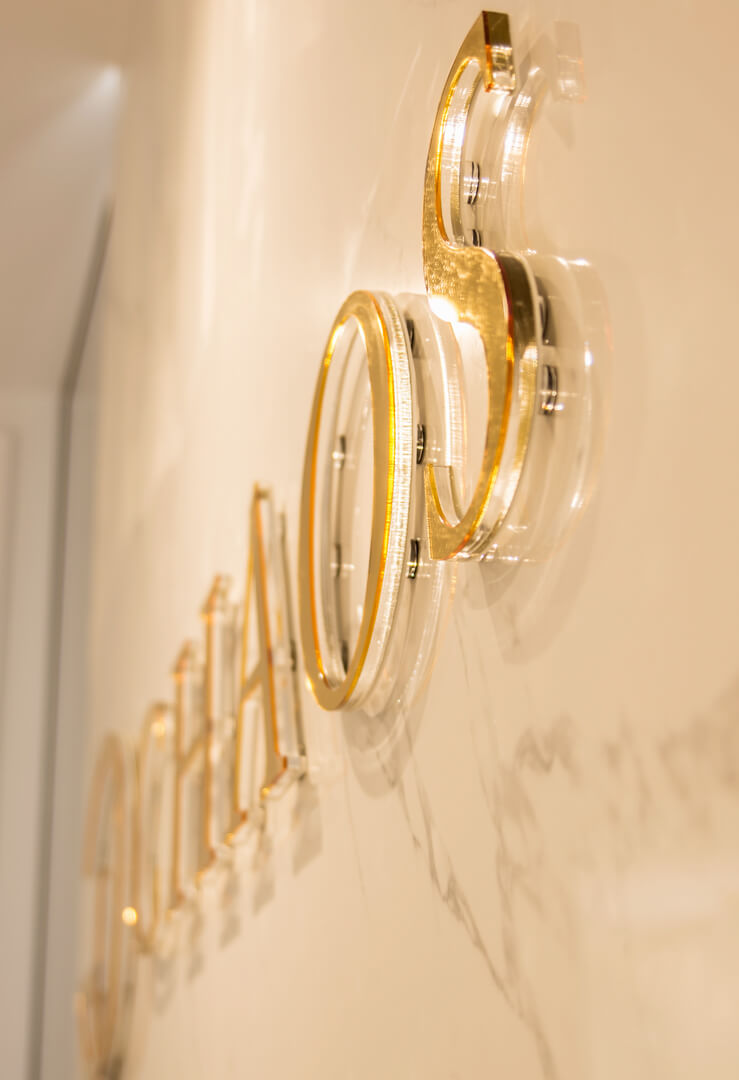 CHAOS - Chaos - złote logo i litery przestrzenne 3D wykonane z plexi umieszczone na ścianie