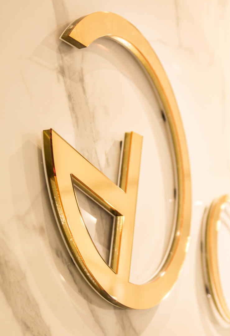 CHAOS - Chaos - złote logo przestrzenne 3D wykonane z plexi umieszczone na ścianie