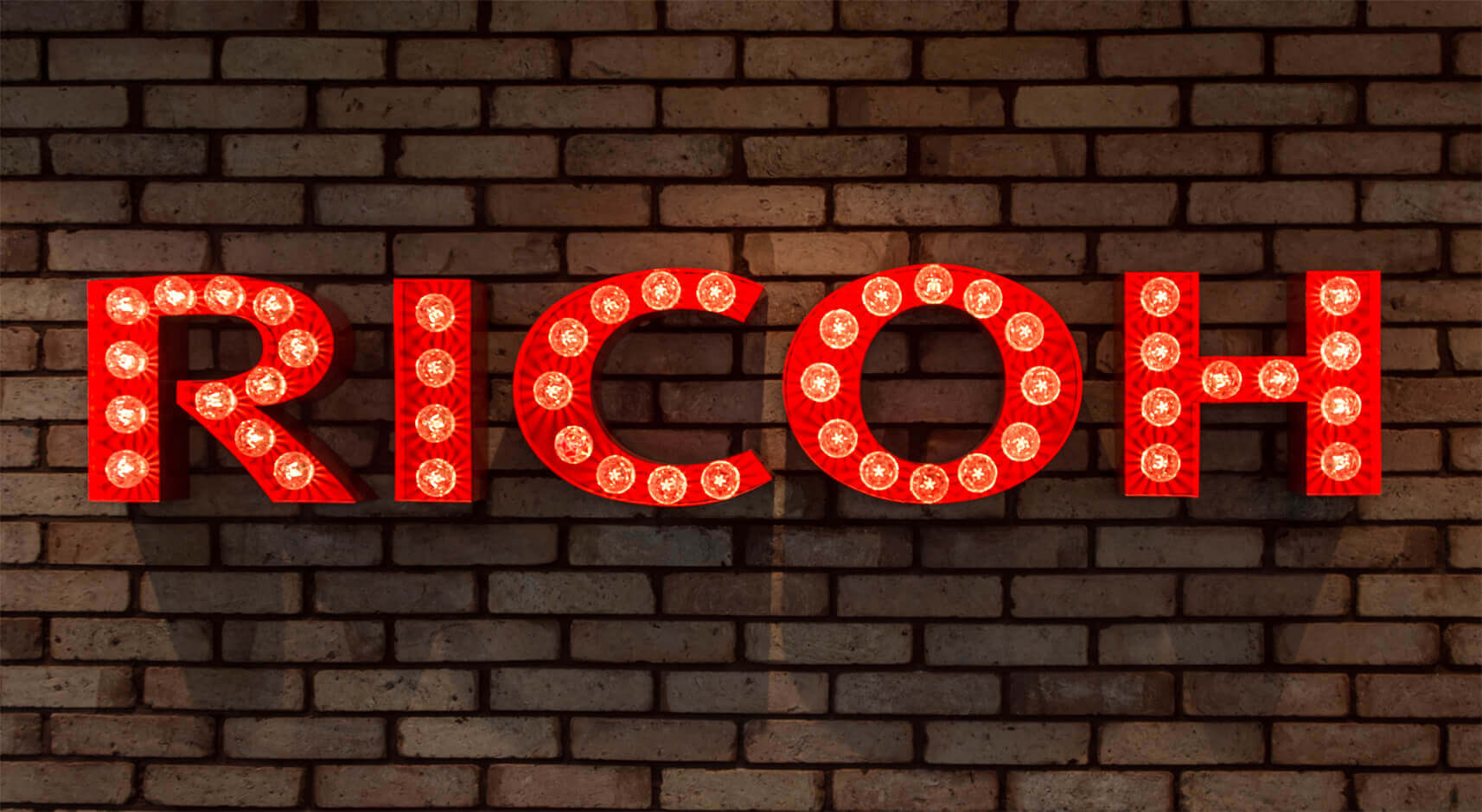 RICOH - RICOH - Letras con bombillas en una pared de ladrillo